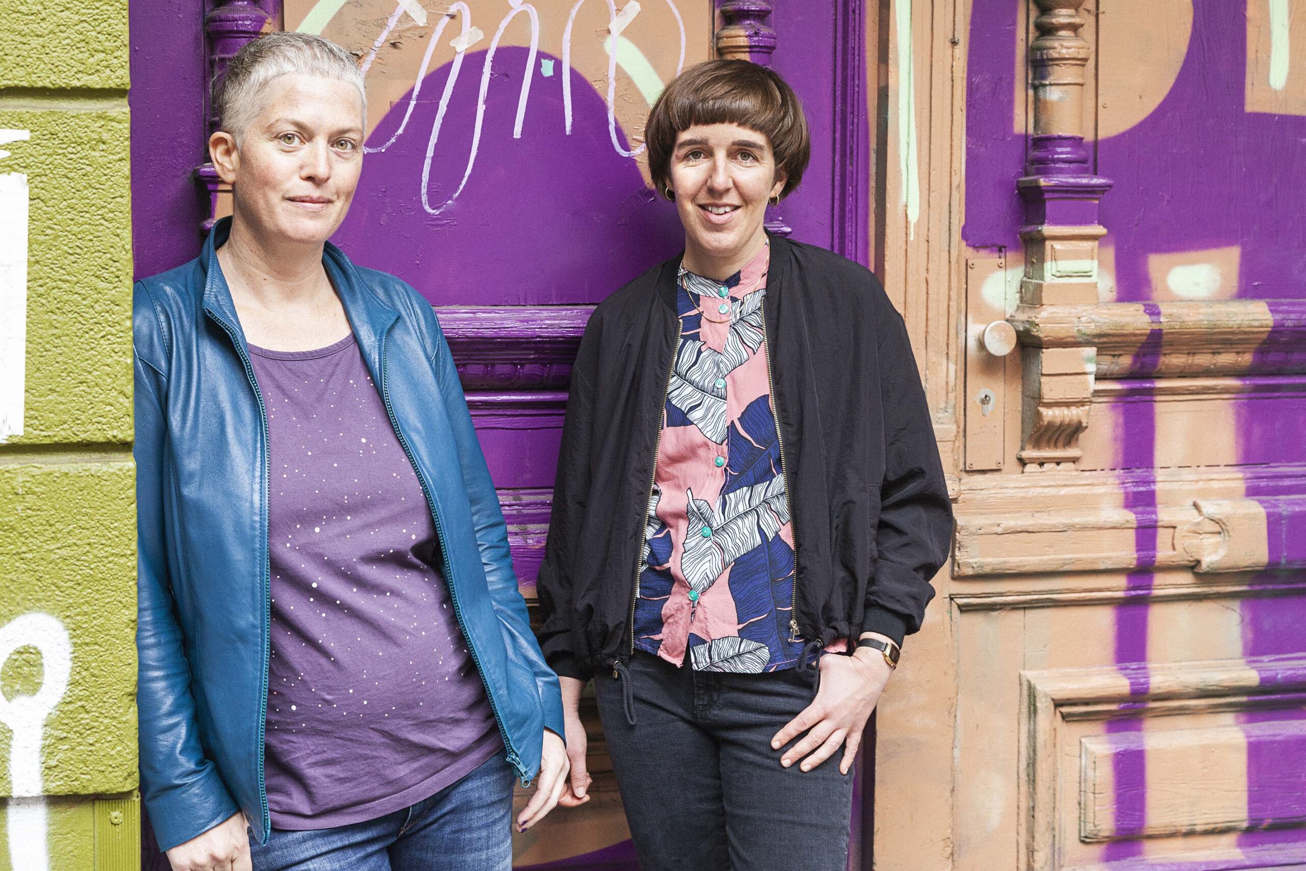 Judith Coffey und Vivien Laumann stehen vor einer Altbautür